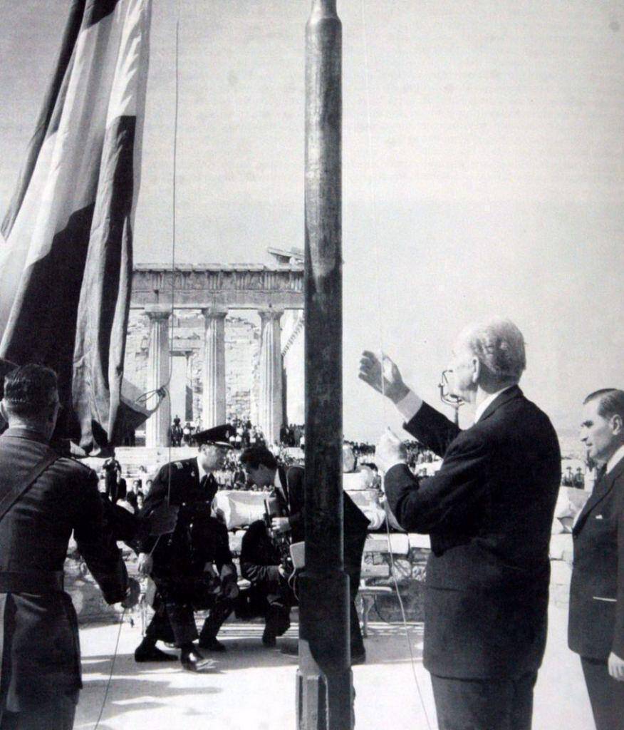 Ο πρωθυπουργός Γ. Παπανδρέου υψώνει τη γαλανόλευκη στον Ιερό Βράχο. Από τότε καθιερώθηκε η 18η Οκτωβρίου ως μέρα απελευθέρωσης της Αθήνας.